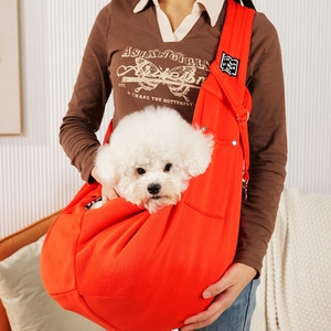 Detail of soft orange pet sling carrier with wide shoulder strap for small dogs