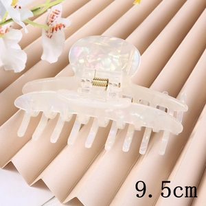 Detail view of 9.5cm pearlescent white acetate hair claw clip with golden spring mechanism