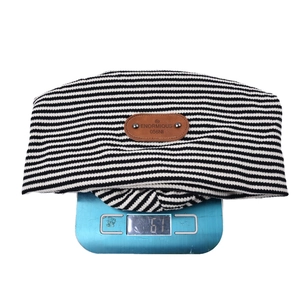 Detail view of the striped beanie weighing 61g on a digital scale for accuracy