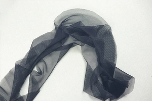 Gros plan sur la texture du tissu en maille noire montrant les détails fins pour les robes