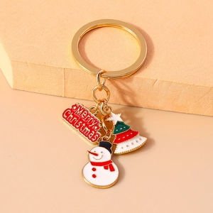Detail of Christmas keychain with snowman, tree and Merry Christmas plaque on gold ring