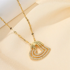 Close-up of a three-layer hollow heart necklace with white zircon on champagne silk