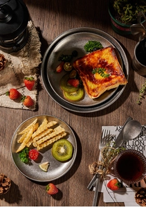 Flat lay of vintage 304 stainless steel dinner plate with toast and cutlery on dark wood