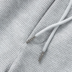 Detalle de la textura de tela gofre gris con cordón y herrajes metálicos de calidad