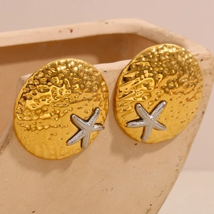 Macro detail of two-tone gold and silver starfish earrings with textured hammered finish