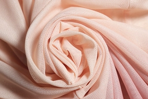 Macro shot of pink gradient knit mesh fabric showing soft texture and detailed weave