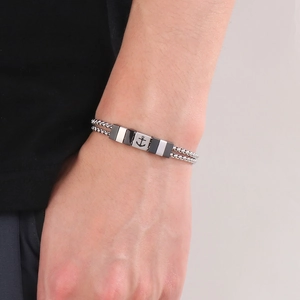 Close-up of dual stainless steel ball chains featuring an engraved nautical anchor charm