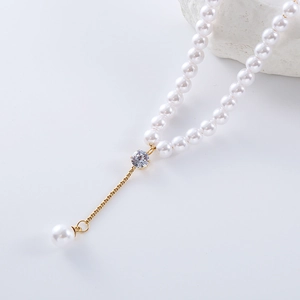 Elegant Y-shaped gold necklace with round white freshwater pearls and crystal pendant