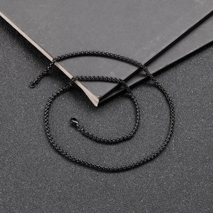 Macro shot of black titanium steel wheat chain texture against minimalist dark background