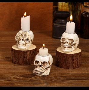 Three-piece skull candle holders in no-hear, no-see, no-speak poses for Halloween