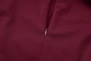 Detailed close-up of wine red dress featuring smooth fabric and a matching invisible zipper
