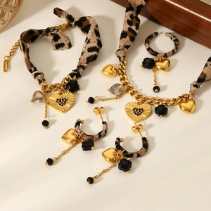 Detail of leopard print heart pendants and gold chain bracelets with earrings set