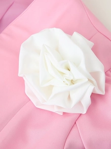 Détail du haut rose à manches courtes avec une grande fleur blanche en tissu 3D