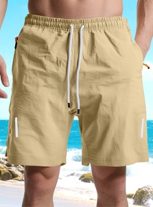 Detail view of khaki quick-dry shorts featuring elastic waistband and zipper pockets