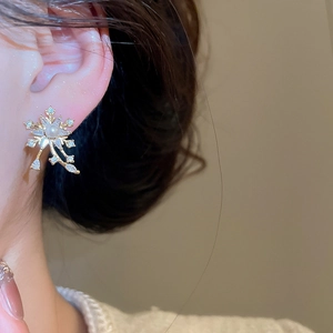 Elegant snowflake pearl earrings with zircon petals on model for a refined vintage look