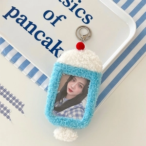 Detail of plush bunny photocard holder with blue accents and silver keychain attachment