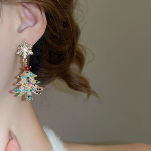 Close-up of model wearing Christmas tree and snowflake pearl tassel earrings with crystals