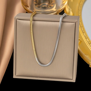Two-tone gold and silver herringbone snake chain necklace on jewelry gift box