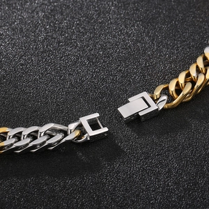 Close-up of two-tone gold and silver Cuban link chain with detailed box clasp mechanism