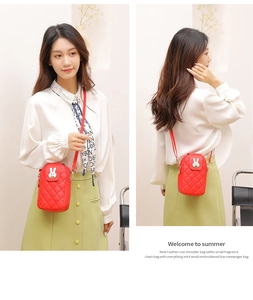 Detail of red quilted leather crossbody bag featuring a white rabbit embroidery