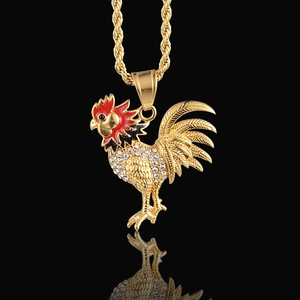 Macro shot of gold rooster pendant with sparkling crystals and red enamel detail