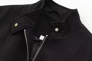 Detail of a black bomber jacket showing stand collar, zipper, and silver metal buttons