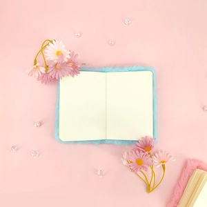 Detailweergave van blauw pluche A7-notitieboek met blanco pagina's op roze achtergrond