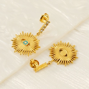 Detailed close-up of gold-plated evil eye earrings with zircon accents and sunburst design