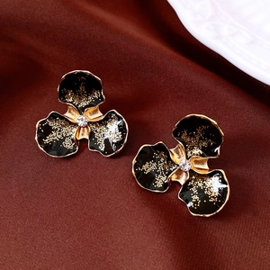 Vue détaillée de boucles d'oreilles fleurs vintage aux pétales noirs et cristaux