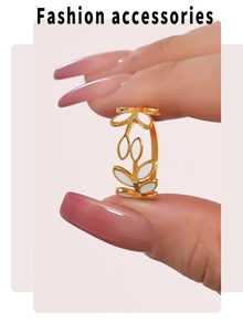 Detail of adjustable gold ring with white enamel leaf design held by fingers