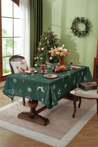 Detail view of festive green Christmas tablecloth with white snowflake and reindeer prints