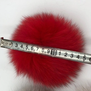 Détail d'un pompon en fourrure de renard rouge mesurant 10-12 cm pour accessoires