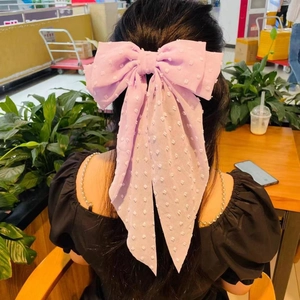 Detail of lavender oversized bow hair clip with swiss dot texture and long ribbons on hair