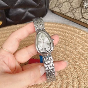 Macro shot of silver drop-shaped watch dial and snake scale metal strap detail