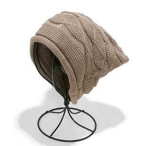 Macro detail of khaki cable knit beanie showing thick warm texture and slouchy pattern