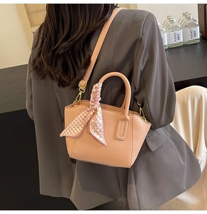 Detail of peach pink lychee grain bucket bag with floral silk scarf on the handle