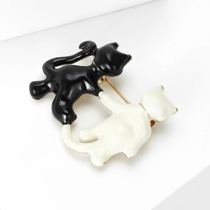 Close-up of black and white enamel cat brooch with intricate metal base detailing