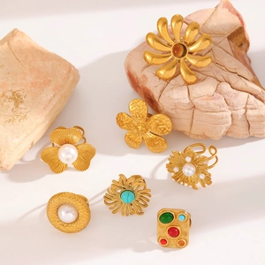 Bohemian gold ring set with turquoise, pearls, and colorful stones on stone props