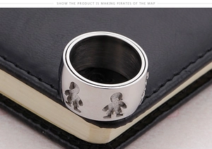 Macro shot of stainless steel ring featuring cutout boy and girl silhouette charms