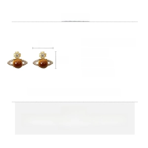 Macro detail of saturn stud earrings with crystals and brown resin center, 1.4x1.8cm size