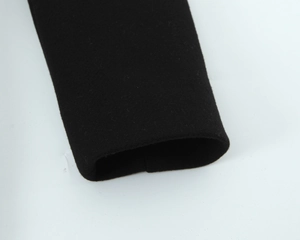 Close-up of black wool coat cuff showing high-quality fiber texture and stitching detail