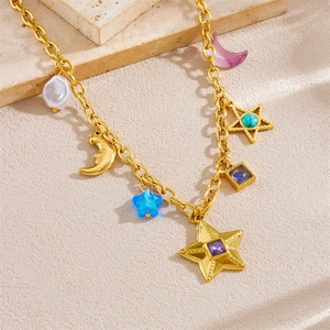 Goldene Edelstahlkette mit Perlen-, Mond- und Sternanhängern auf Steindekoration