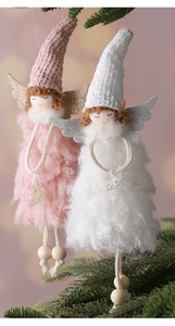 Detail of plush Christmas angel dolls in pink and white hanging on a festive tree branch
