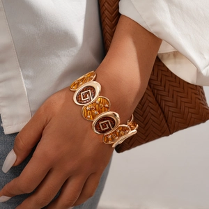 Close-up of a vintage gold-toned elastic bracelet with amber star-patterned oval charms