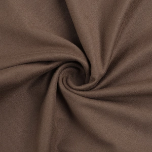 Gros plan sur un tissu en maille marron montrant la texture douce et les plis