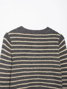 Close-up of the ribbed crew neck and grey and beige striped knit texture on the sweater