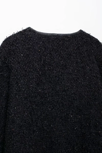 Détail du dos d'une veste en tweed avec mélange de fibres et bordure en cuir noir