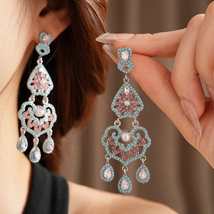 Gros plan de boucles d'oreilles vintage avec perles bleues et strass roses sur mannequin