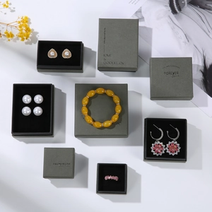 Elegant grey cardboard jewelry gift boxes displayed with various luxury ornaments