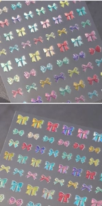 Macro shot of 3D embossed laser bow nail stickers with iridescent glitter finish
